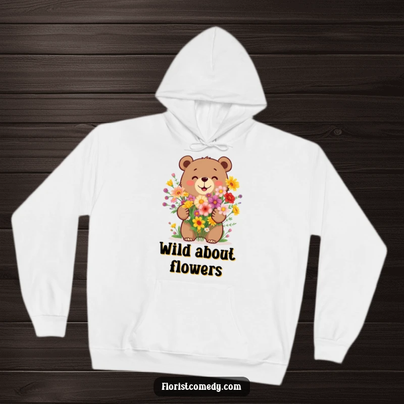 Funny bear hoodie showing a happy bear arranging a bouquet of colorful wildflowers, radiating warmth and natural beauty.